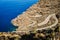 Steep and twisty road down a mountain towards the ocean. Turquoise water. Road trip La Palma. Mountain landscape. Poris de