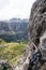Steep Via Ferrata with steel cable and clamp and carabiners and a view of the Dolomites behind