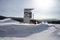 Stele with the logo of the company RUSAL stands on the snowdrift against the background of the taiga.