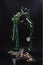 Stem of bindweed with pink flowers in green glass bottle on dark planks on dark background