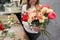 Step by step florist woman creates red beautiful bouquet of mixed flowers. Handsome fresh bunch. Education, master class