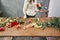 Step by step florist woman creates red beautiful bouquet of mixed flowers. Handsome fresh bunch. Education, master class