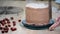 Step-by-step preparation of black designer cake. The confectioner covers the cake with cream.