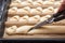 Step by step preparation of bread. French baguette. Forming `Tail of the Dragon`