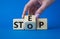 Step vs Stop symbol. Businessman hand turns wooden cubes and changes the word Stop to Step. Beautiful blue background. Step vs