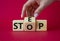 Step vs Stop symbol. Businessman hand turns wooden cubes and changes the word Stop to Step. Beautiful red background. Step vs Stop