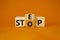 Step vs Stop symbol. Turned wooden cubes with words Stop vs Step. Beautiful orange background. Step vs Stop and business concept.