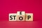 Step vs Stop symbol. Wooden cubes with words Stop and Step. Beautiful red background. Step vs Stop and business concept. Copy