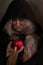 Stepmother witch gives poisoned red apple.Woman as witch in black offers red apple as symbol of temptation, poison.