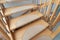 Steps of curved wooden staircase with anti-slip mat