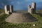 Steps leading to fantasy stone circle temple in a remote highlands landscape with dark stormy clouds. 3D illustration