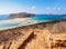 From the steps opens an incredible view on a landscape with a sea of azure color, a sand and mountain beach. A moored ship.