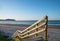 Steps and railing down to wide sandy beach.