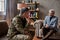 Steps towards wellness. Middle aged military man communicating with psychologist, sitting on the couch during therapy