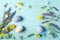 ster eggs, purple and yellow flowers on pastel blue background. Spring, easter concept