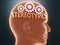 Stereotypes inside human mind - pictured as word Stereotypes inside a head with cogwheels to symbolize that Stereotypes is what