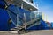 Stern of cargo vessel at port. Gangway arrangment. Blue hull. White superstructure