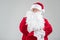 Stern senior grandfather wearing Christmas red and white costume