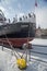 Stern of ship or a steamer mooring in ice during winter in Old Town of Gdansk Poland. Old town in the background.