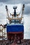 Stern of vessel or ship with visible propeller and ropes being repaired in dock. Back view of docked fishing trawler with