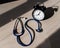 Stethoscope and alarm clock on a wooden table in the sunlight. A tool for measuring blood pressure. Desktop cardiologist