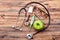 Stethoscope, apple, thermometer and loupe.