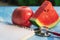 Stethoscope, apple, watermelon and note on blue and wooden table