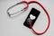 Stethoscope and black smartphone with a heart symbol and heartbeat to show digital doctors office, digital diagnosis