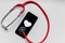 Stethoscope and black smartphone with a heart symbol and heartbeat to show digital doctors office, digital diagnosis