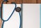 Stethoscope, blank page notepad on the doctor table. Medical diagnosis or doctor prescription mockup