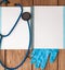 Stethoscope, blank page notepad and gloves on the doctor table. Medical diagnosis or doctor prescription mockup