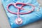 Stethoscope with blue doctor\'s uniform on table