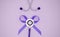 Stethoscope and bow of purple ribbon on a pink background with copy space. Medical flat lay