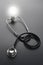 Stethoscope and bulb light on black background