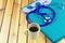 A stethoscope ,coffee cup and blue medical uniform stack on wooden