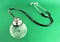 Stethoscope on a crystal globe, conceptual image - green background