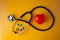 Stethoscope doctors and red heart cardiology placed on a Yellow table in the hospital,  concept: diagnostics disease health presc