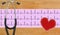 stethoscope, electrocardiogram graph (ECG) and textile heart over wooden background