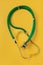 A stethoscope is isolated on a yellow background. The concept of medical equipment, cardiology, lung diagnosis, coronavirus,