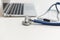 Stethoscope and laptop on doctor working desk, business and health care concept