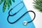 Stethoscope and leaves on a blue background. creative minimalism, Health and hygiene concepts.