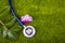 Stethoscope, leaves and orchid on green grass