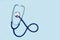 A stethoscope on a light blue background in a top view