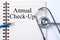 Stethoscope on notebook and pencil with Annual Check-Up words as