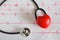 Stethoscope with red heart ball on paper heart sign