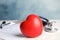 Stethoscope, red heart and cardiogram on table