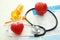 Stethoscope with red heart and lists of laboratory tests on white background.  Health care concept