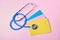 Stethoscope and several colored envelopes on pink background doctor`s day, health care day concept