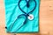 Stethoscope shaping heart and clipboard on medical uniform, closeup