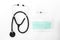 Stethoscope, syringe and mask on white background